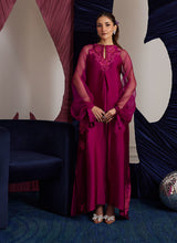 Load image into Gallery viewer, This magenta Sheesha Silk shirt is a stunning embodiment of contemporary elegance, seamlessly blending classical romance with modern flair. The shirt flows gracefully, adorned with delicate floral appliqués that add a soft, feminine touch, while meticulous embroidered details weave through the fabric, creating intricate patterns that enhance the shirt’s luxurious appeal. The statement balloon sleeves, tied with ribbons and bows, bring a dramatic, yet playful dimension to the design, adding volume and a sens