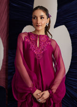 Load image into Gallery viewer, This magenta Sheesha Silk shirt is a stunning embodiment of contemporary elegance, seamlessly blending classical romance with modern flair. The shirt flows gracefully, adorned with delicate floral appliqués that add a soft, feminine touch, while meticulous embroidered details weave through the fabric, creating intricate patterns that enhance the shirt’s luxurious appeal. The statement balloon sleeves, tied with ribbons and bows, bring a dramatic, yet playful dimension to the design, adding volume and a sens