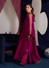Load image into Gallery viewer, This magenta Sheesha Silk shirt is a stunning embodiment of contemporary elegance, seamlessly blending classical romance with modern flair. The shirt flows gracefully, adorned with delicate floral appliqués that add a soft, feminine touch, while meticulous embroidered details weave through the fabric, creating intricate patterns that enhance the shirt’s luxurious appeal. The statement balloon sleeves, tied with ribbons and bows, bring a dramatic, yet playful dimension to the design, adding volume and a sens