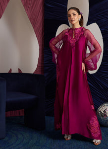 This magenta Sheesha Silk shirt is a stunning embodiment of contemporary elegance, seamlessly blending classical romance with modern flair. The shirt flows gracefully, adorned with delicate floral appliqués that add a soft, feminine touch, while meticulous embroidered details weave through the fabric, creating intricate patterns that enhance the shirt’s luxurious appeal. The statement balloon sleeves, tied with ribbons and bows, bring a dramatic, yet playful dimension to the design, adding volume and a sens