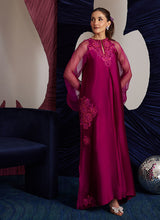 Load image into Gallery viewer, This magenta Sheesha Silk shirt is a stunning embodiment of contemporary elegance, seamlessly blending classical romance with modern flair. The shirt flows gracefully, adorned with delicate floral appliqués that add a soft, feminine touch, while meticulous embroidered details weave through the fabric, creating intricate patterns that enhance the shirt’s luxurious appeal. The statement balloon sleeves, tied with ribbons and bows, bring a dramatic, yet playful dimension to the design, adding volume and a sens
