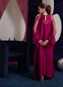 This magenta Sheesha Silk shirt is a stunning embodiment of contemporary elegance, seamlessly blending classical romance with modern flair. The shirt flows gracefully, adorned with delicate floral appliqués that add a soft, feminine touch, while meticulous embroidered details weave through the fabric, creating intricate patterns that enhance the shirt’s luxurious appeal. The statement balloon sleeves, tied with ribbons and bows, bring a dramatic, yet playful dimension to the design, adding volume and a sens