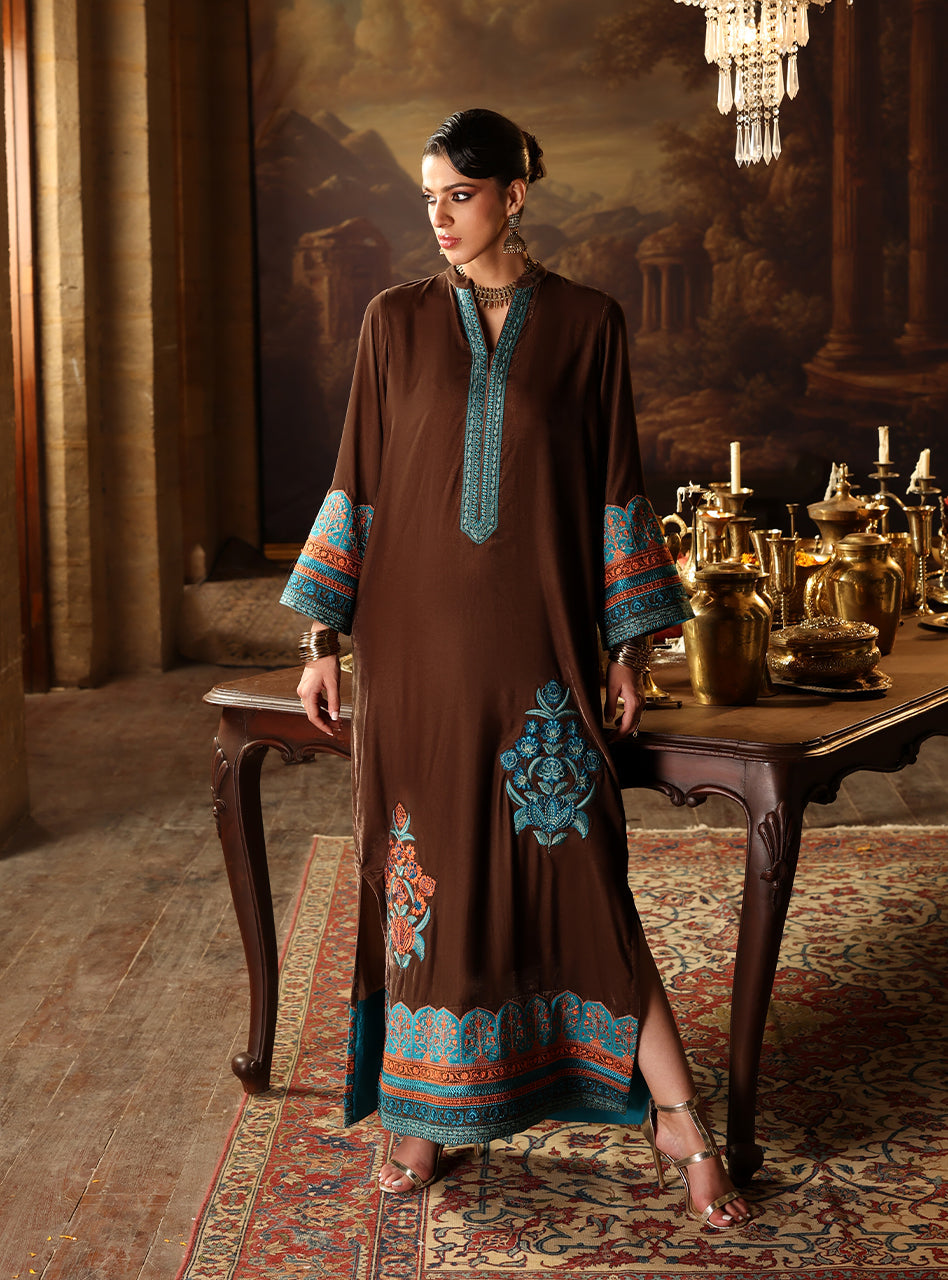 Experience the relaxed luxury of Sienna Kaftan, a kaftan that truly allows you to move with effortless grace while looking impeccably put-together. Cut from soft, draping Brown Velvet, this piece feels like a comforting embrace, blending warmth with high fashion. The drama lies in the contrasting Teal, Blue, and Rust embroidery that boldly defines the neckline, cuffs, and sweeping side panels, giving the kaftan a vibrant, modern edge.